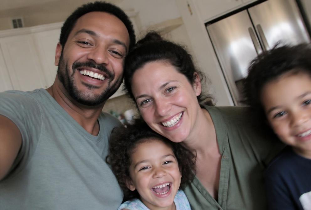 A family squeezing into a selfie at home